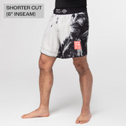 Person wearing black and white patterned shorts on a plain background