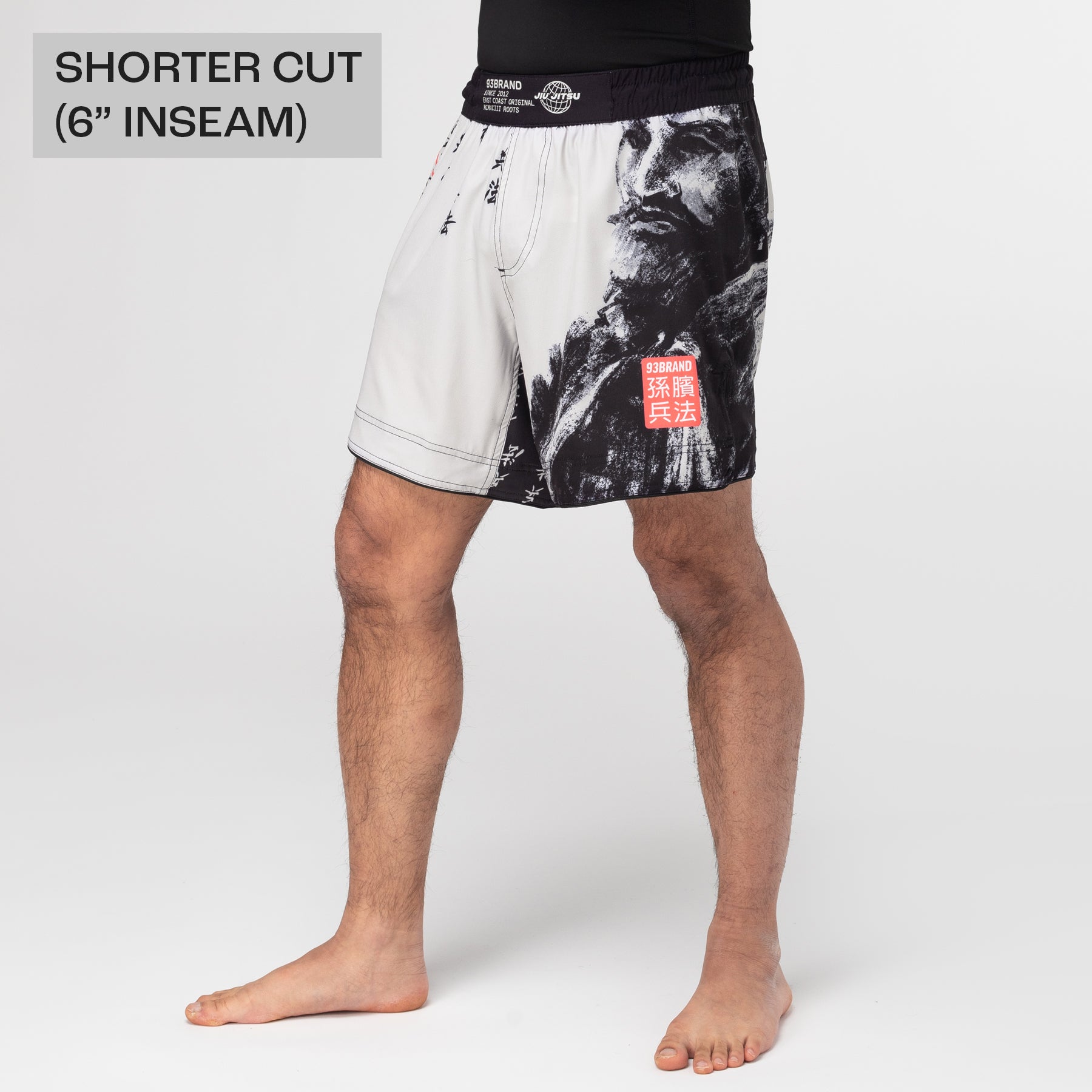 Person wearing black and white patterned shorts on a plain background